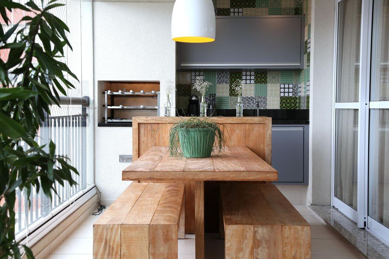 Área gourmet com churrasqueira pequena e moveis de madeira rustica para decorar o espaço