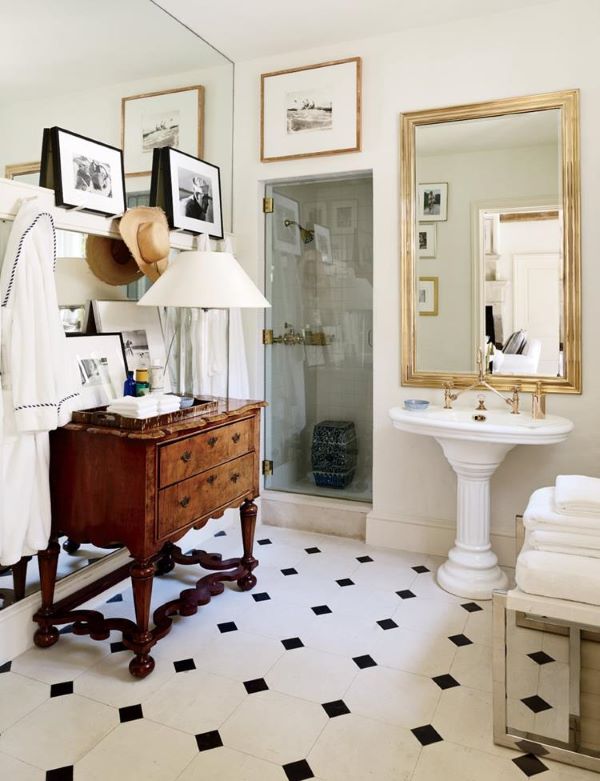 Decoração de banheiro retro com cômoda de madeira e espelho dourado