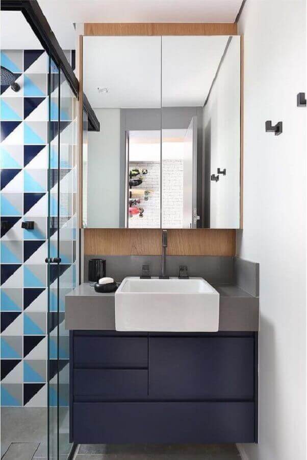 Banheiro retrô com revestimento geométrico e gabinete azul marinho
