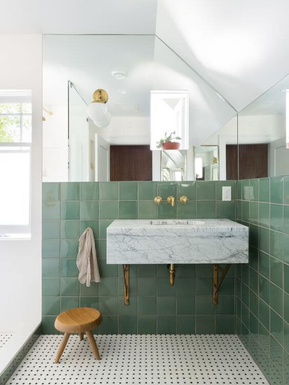 Banheiro retrô com revestimento verde e espelho na parede