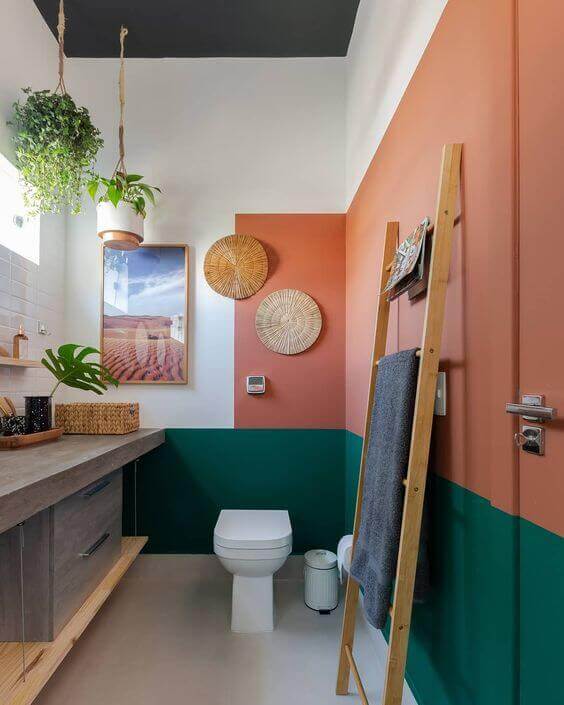 Banheiro retro com parede na cor pêssego e verde geométrico