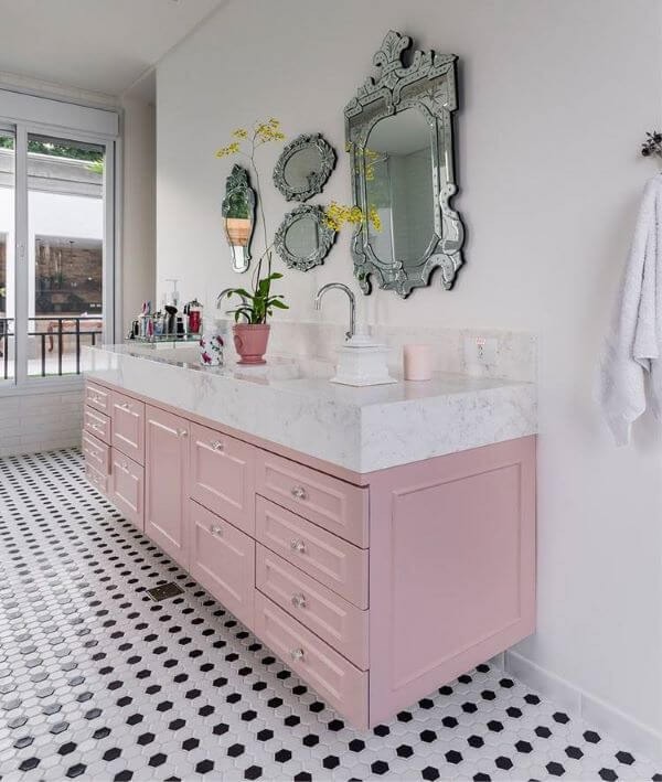 Banheiro retrô com gabinete rosa e bancada de mármore