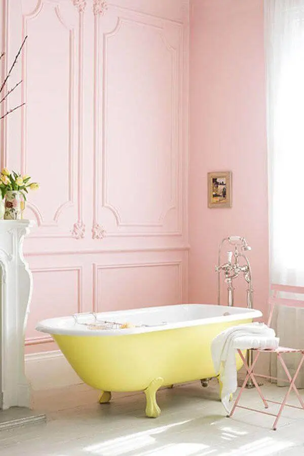 Banheiro retrô cor de rosa com banheira de pé amarela