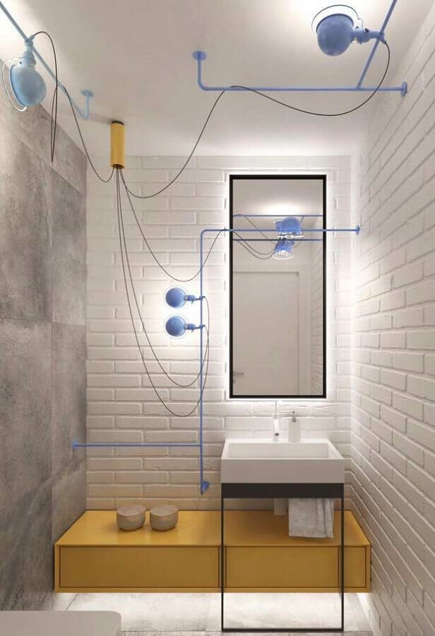 Decoração clean para banheiro industrial com tubulação pintada de azul e parede de tijolinho branco Foto Home Fashion Trend