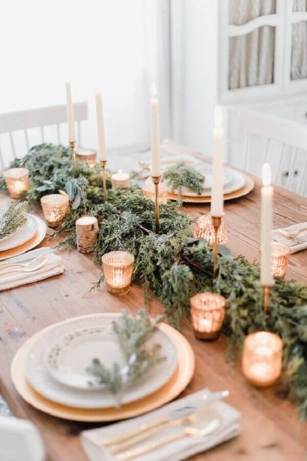Decoração rústica de mesa de ano novo com velas e folhagens Foto Casa Vogue