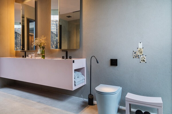 Banheiro moderno com torneira preta e bancada cor de rosa
