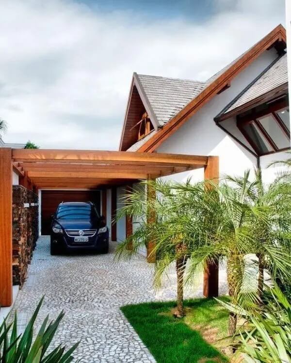 Casa com garagem na lateral com pergolado de madeira. Fonte: Decora Sandra