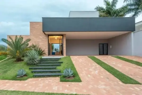 Elabora um bom projeto paisagístico para as casas com garagem lateral. Fonte: Laje 54 Arquitetura