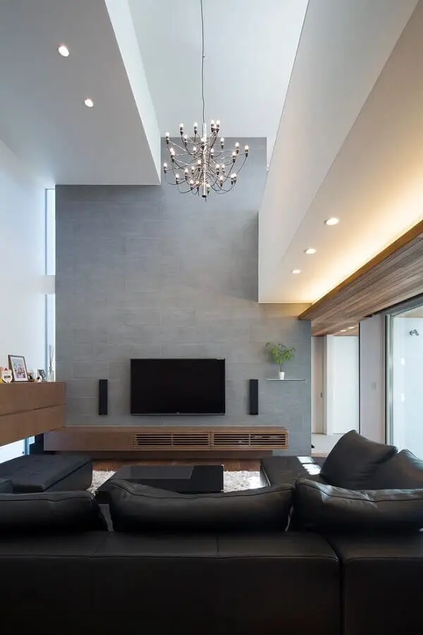 sala moderna decorada com sofá preto e rack de madeira Foto Assetproject