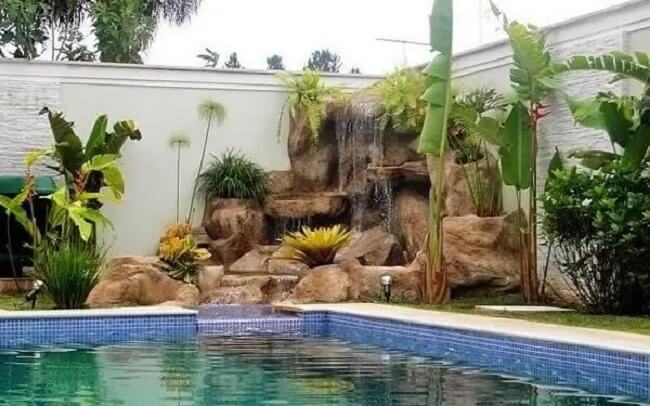 O paisagimo decora a cascata para piscina feita de pedra.