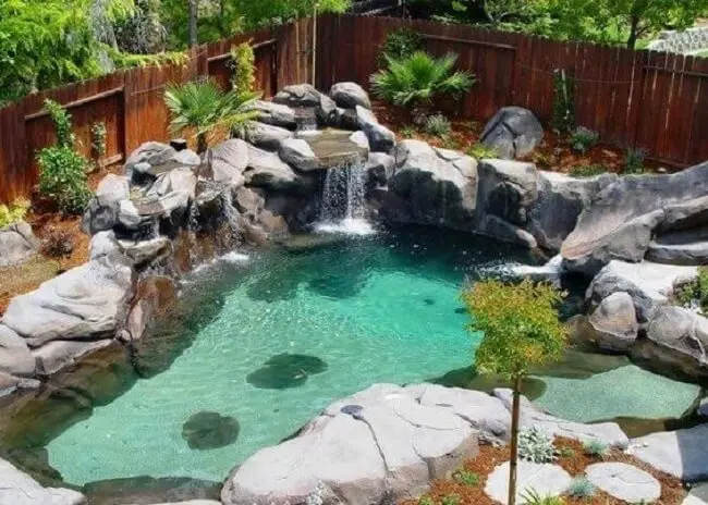 cascata de pedra para piscina agrega valor para a área de lazer. 