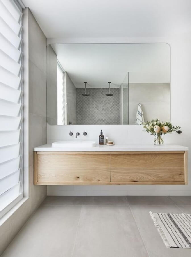 Decoração clean para banheiro planejado com gabinete de madeira suspenso Foto Interiors Addict