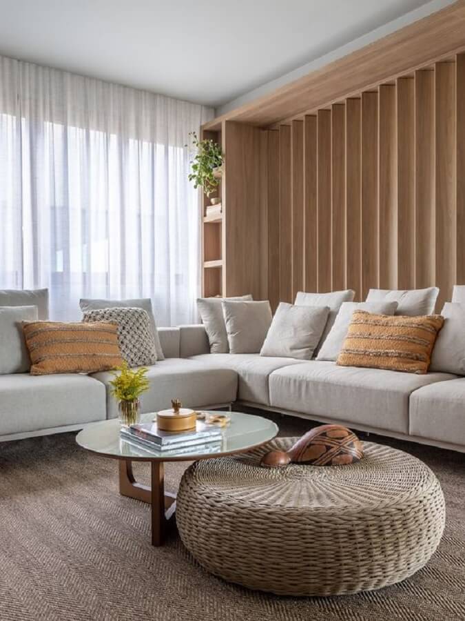Decoração clean para casa em cores neutras com sofá de canto e puff redondo para sala Foto Gabriela Daltro