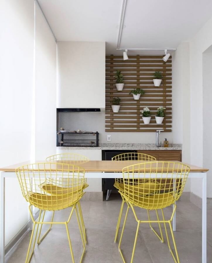 Decoração clean para varanda gourmet com churrasqueira e cadeiras amarelas Foto Decor Fácil