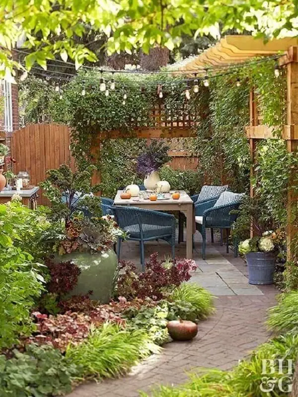 Jardim decorado com mesa para área externa e luminária externa no pergolado