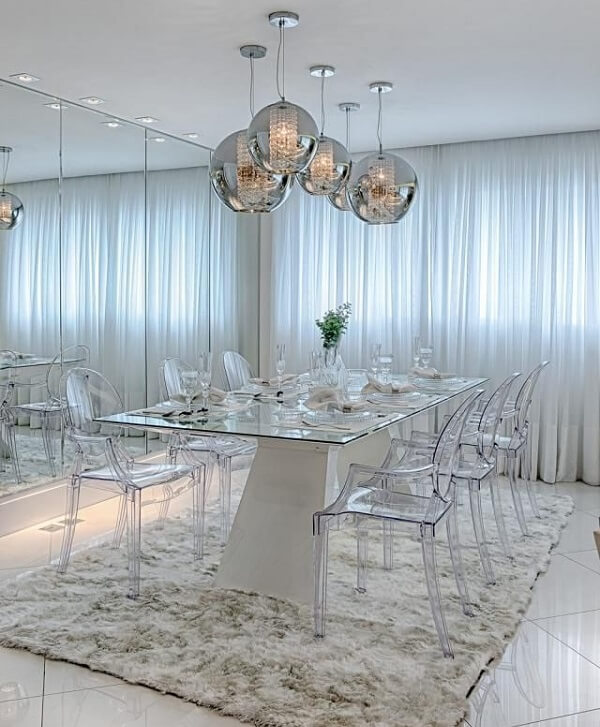 Sala de jantar com parede espelhada e luminárias de teto metálicas
