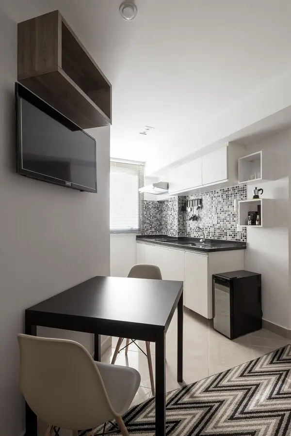 Cozinha compacta com mesa de parede preta.