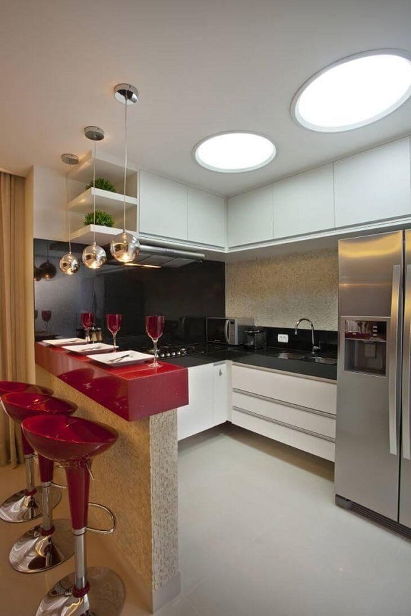 Cozinha branca e preta com bancada americana em granito vermelho estelar