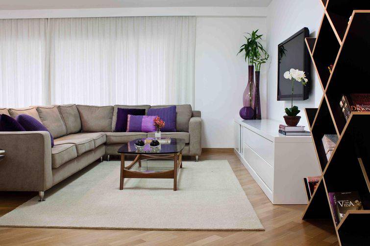 Sofás de canto com cores neutras podem ser acompanhados com almofadas coloridas