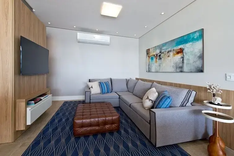 Sofá de canto cinza e tapete azul para decoração da sala de estar