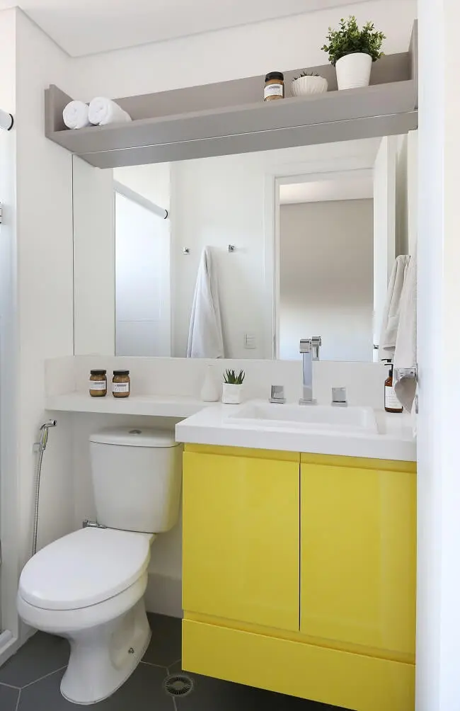 O gabinete amarelo traz alegria para a decoração do banheiro feminino