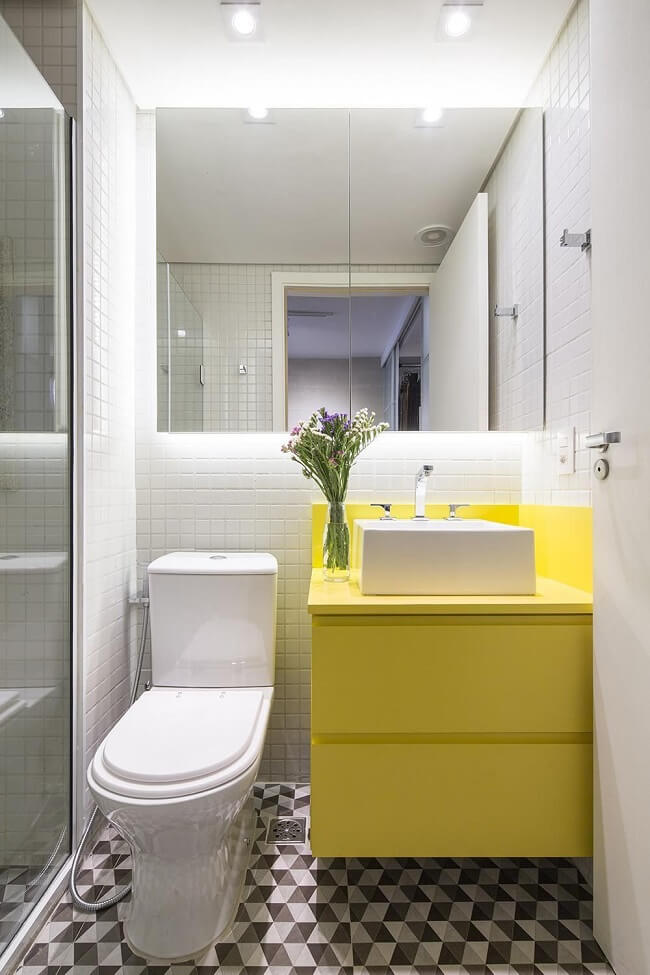 Banheiro feminino pequeno com gabinete amarelo