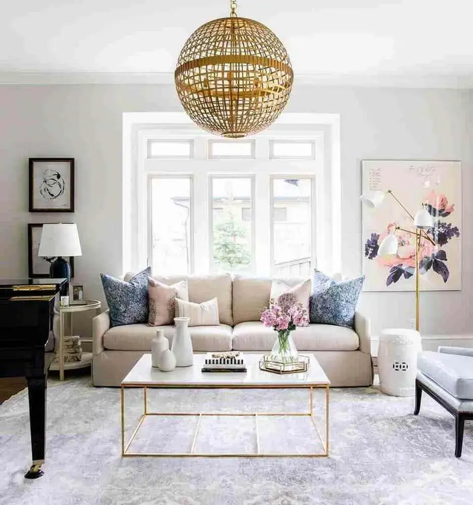 enfeites decorativos para sala de estar sofisticada com mesa de centro dourada e sofá bege Foto Diseno Interior