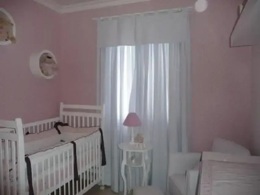 quarto de bebê feminino simples e barato decorado com papel de parede cor de rosa e nichos redondos Foto Carla Teles Vaz