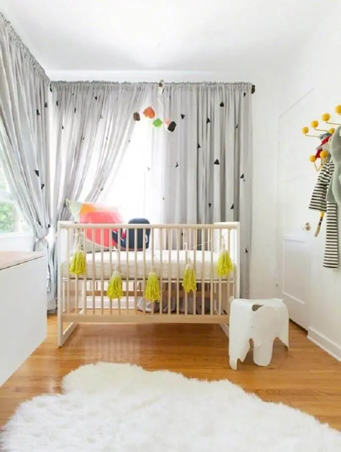 quarto de bebê simples decorado com tapete branco felpudo e cortina cinza Foto Arquitrecos