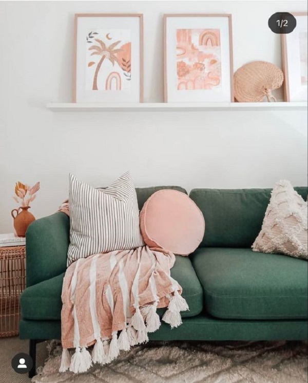 Decoração moderna com manta rosa no sofá verde