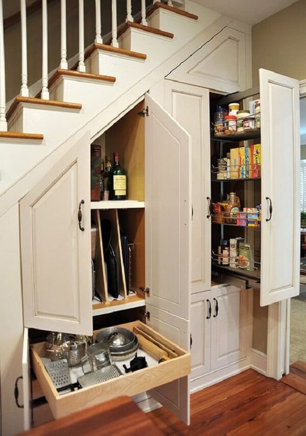 Armário embaixo da escada na cozinha: portas e gavetas que ajudam na organização de itens