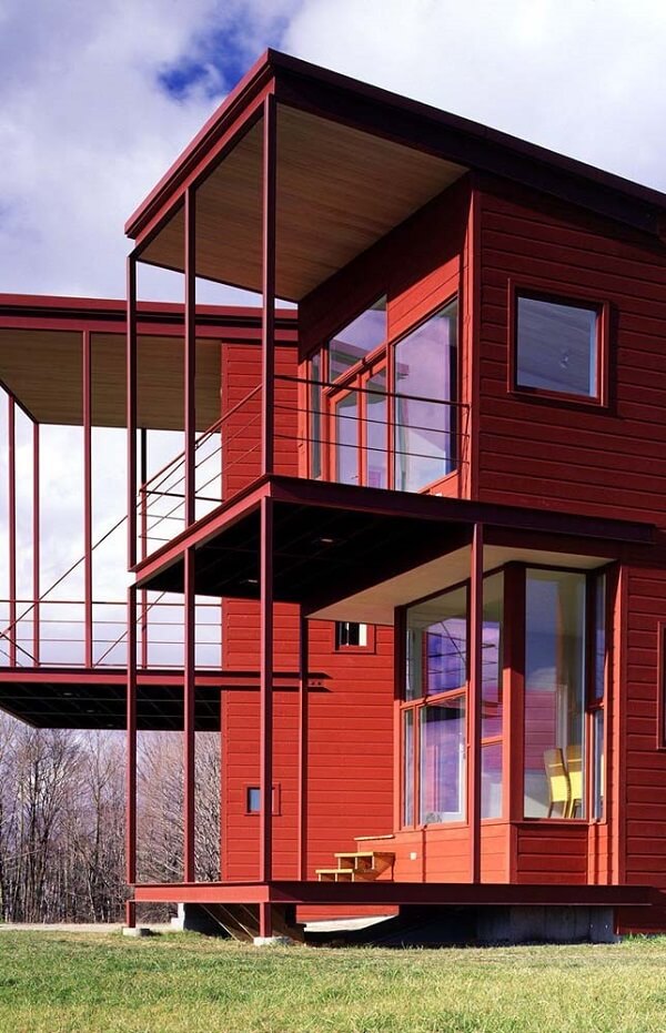Modelo de casa vermelha que valoriza a entrada de luz natural