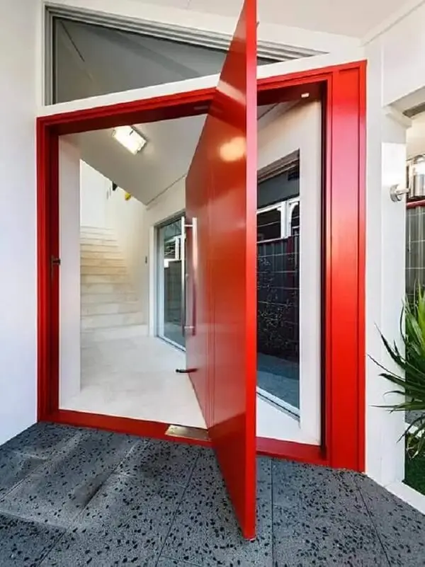 Casa com porta vermelha pivotante é sinônimo de elegância