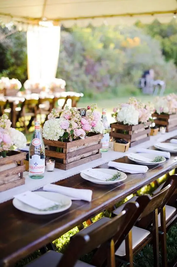 decoração de festa de casamento com arranjos de flores dentro de caixotes de madeira Foto WeddBook